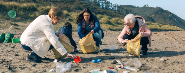 istock Female volunteers cleaning the beach 1161268145