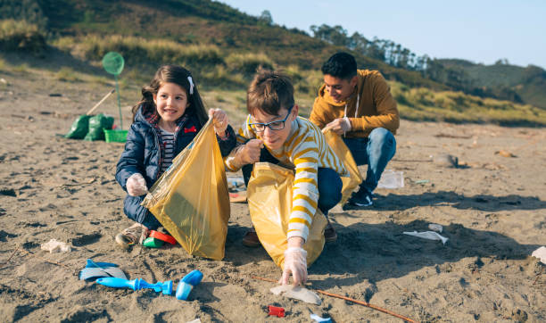 young volunteers cleaning the beach - wasting time imagens e fotografias de stock