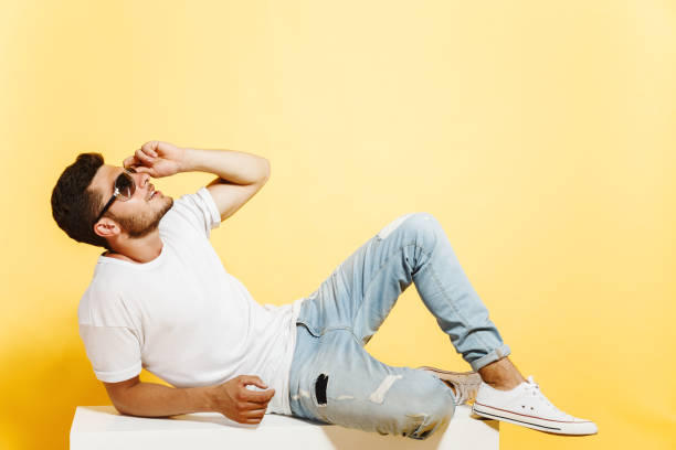 istock Handsome tanned man lying on white box 1161270209