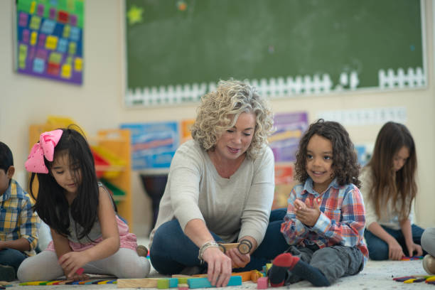 istock Caucasian female teacher playing blocks with her students 1161275037