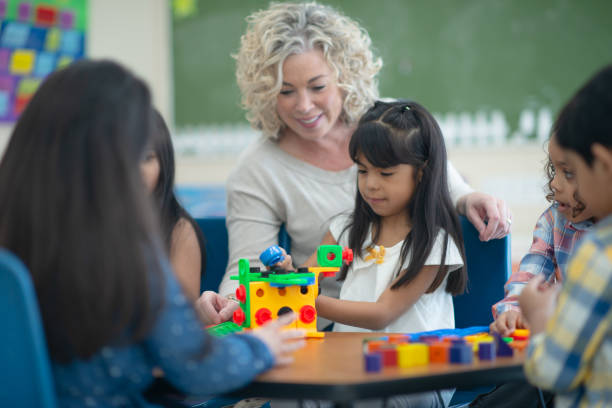 istock Caucasian teacher plays with her female ethnic student 1161275072