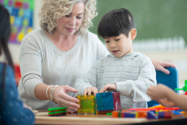 istock Caucasian teacher plays magnetic blocks with her ethnic student 1161275079