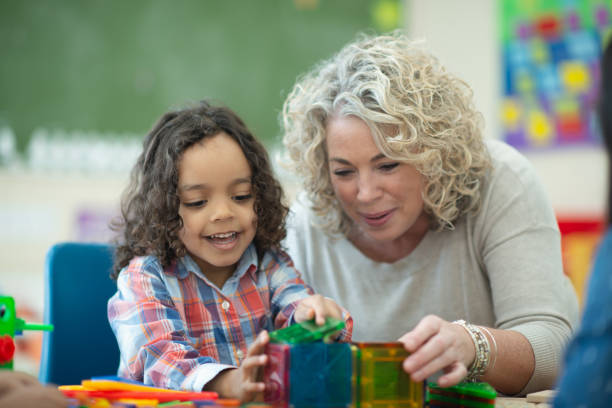 istock Caucasian teacher plays magnetic blocks with her ethnic student 1161275081