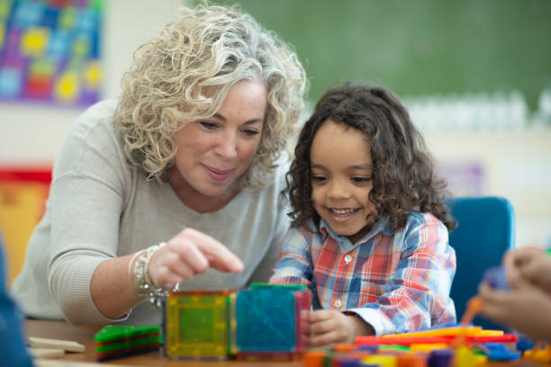 istock Caucasian teacher plays magnetic blocks with her ethnic student 1161275082
