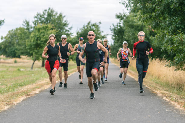 istock Co-ed group of senior triathletes running 1161275933