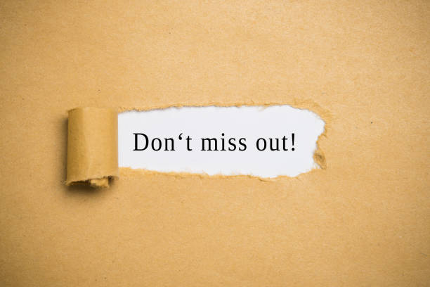 Don't Miss Out concept with revealed message behind a torn strip of brown paper in a full frame view with copy space