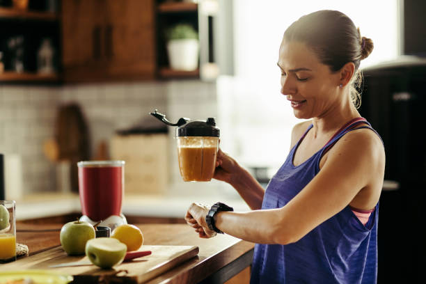 è persistente nel suo stile di vita sano! - women juice drinking breakfast foto e immagini stock