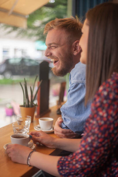 istock laughing friends drinking coffee in a cafe. 1161290612