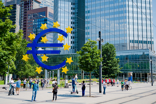 Large Euro symbol sculpture outside the European Central Bank in Frankfurt Main, Germany.\n\nPeople clearly visible