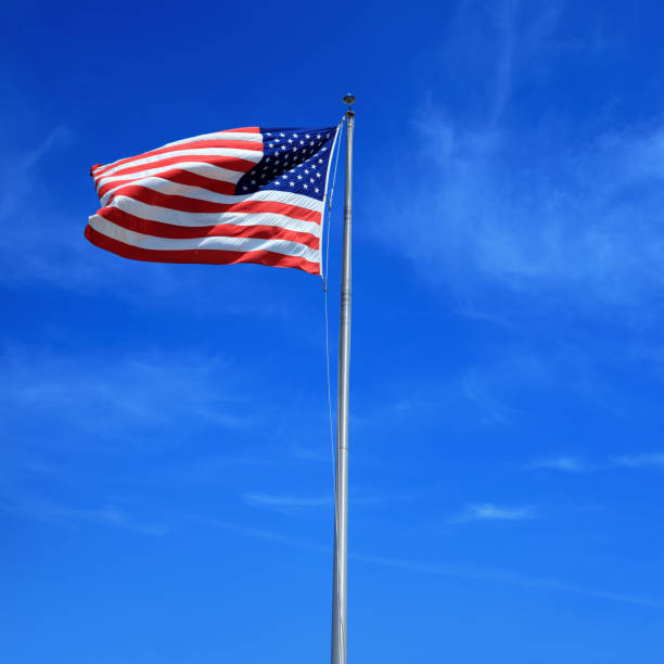 istock American flag at tall flagpole over clear blue sky 1161295620