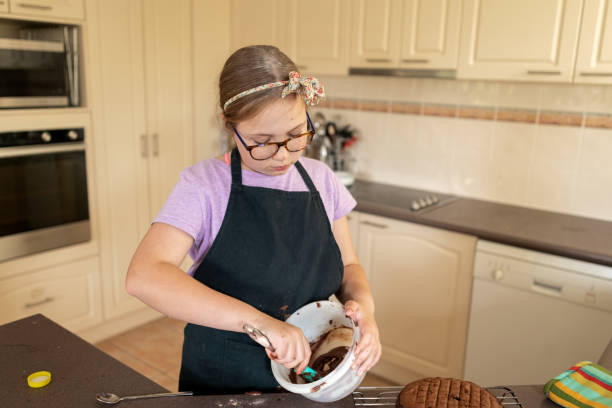 istock Young Girl Preparing Icing For Chocolate Cake 1161295937