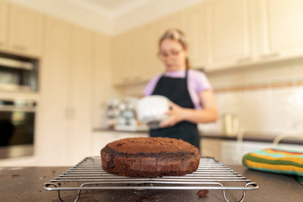 Young Girl Baking A Cake In The Kitchen Of Australian House