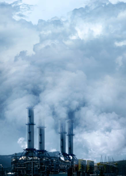 close up industrial factory with tall chimneys over smoke covered sky in Turkey