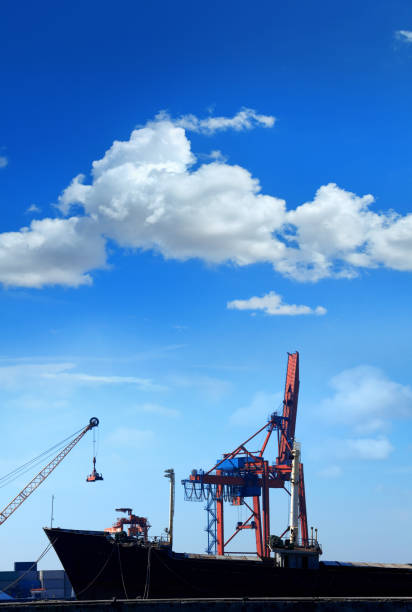 Freight Transportation image of cargo ship and cranes at port over blue sky and clouds in Istanbul, Turkey