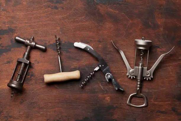 Various wine corkscrews on wooden table. Top view flat lay with copy space for your text