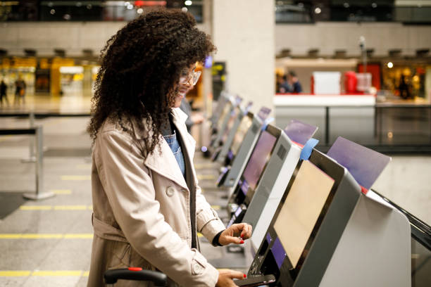 vrouw doen zelf inchecken op de luchthaven met mobiele telefoon - self service stockfoto's en -beelden