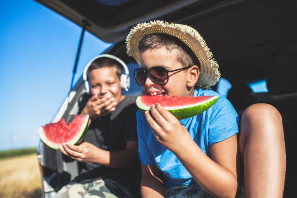 gosses mangeant la pastèque à l'extérieur - watermelon fruit healthy eating snack photos et images de collection