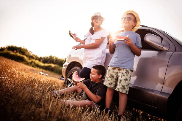 famiglia felice che mangia anguria a un picnic - car family picnic vacations foto e immagini stock