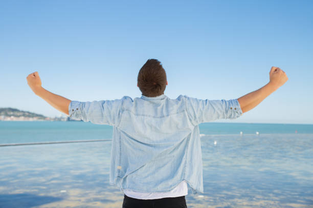 istock Rear view of ecstatic young man enjoying summer vacations 1161309986