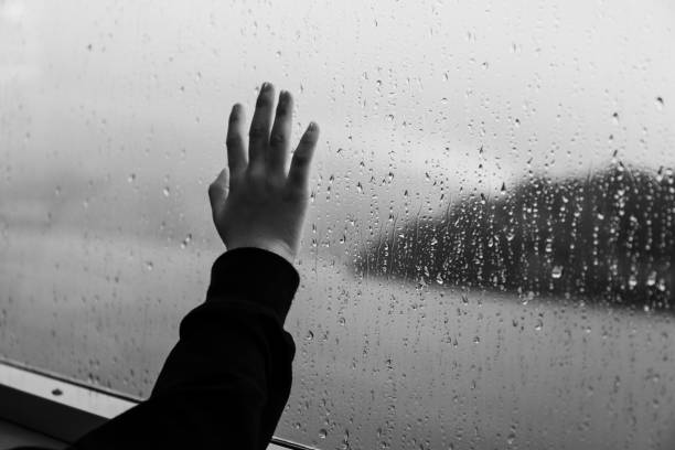 hand on the window in the raining day stock photo