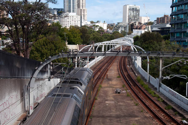 istock Electric train moving away along suburban train track 1161314369