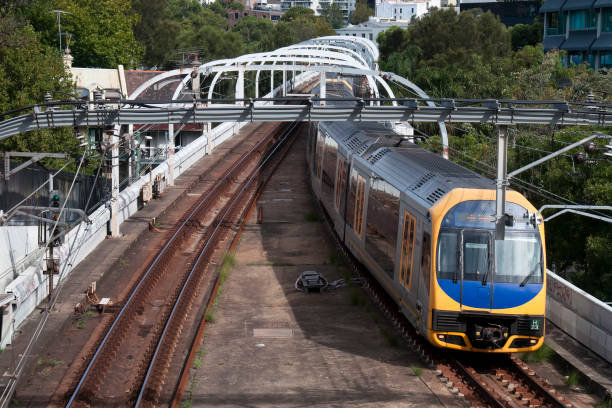 treno in avvicinamento lungo i binari del treno suburbano - train australia electric train image foto e immagini stock