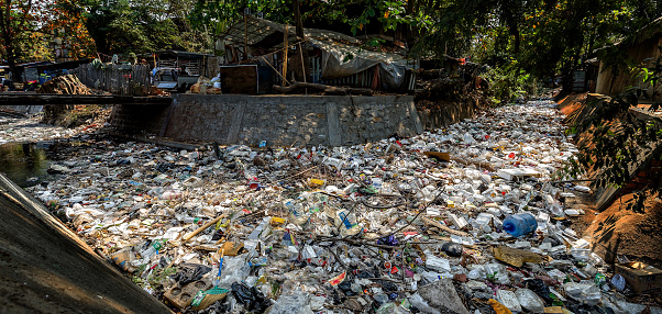 a waterway in Asia clogged with plastic pollution and garbage so thick you can no longer see the water underneath.