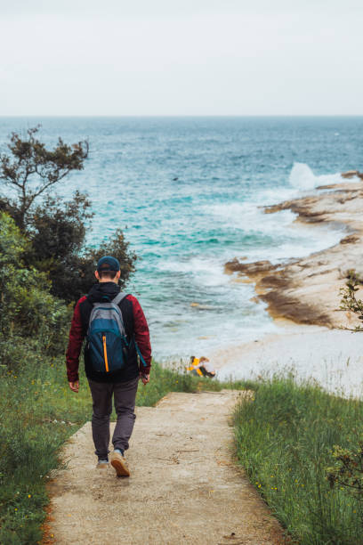 istock man walking by trial to sea beach overcast weather 1161315281