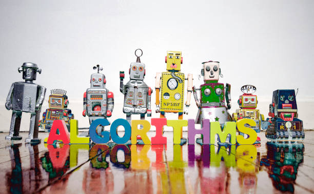 istock a line of retro robots on a wooden floor with the word ALGORITHMS 1161315617