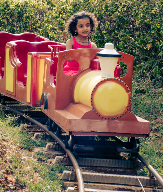 Low-angle wide shot of an inverted rollercoaster as the train goes over a loop against the sky