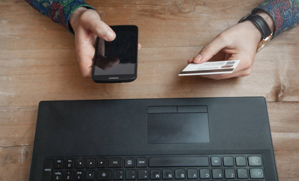 istock Man holding credit card and using phone. 1161317630