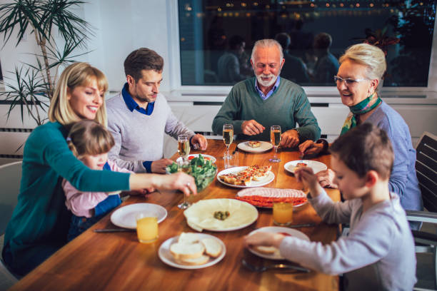 istock Multi generation family enjoying meal around table at home 1161320191