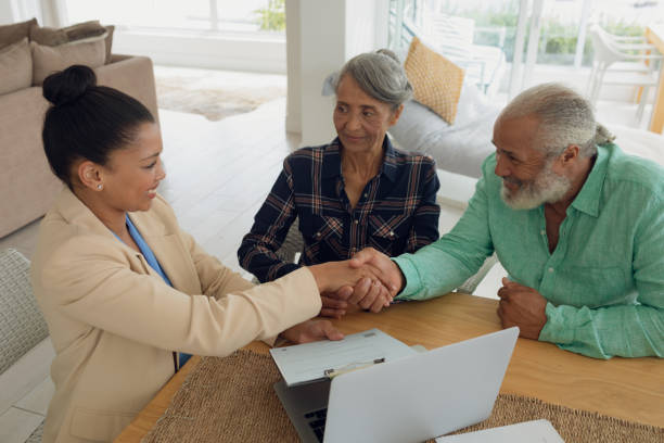 istock Man shaking hands with financial adviser while sitting beside wife 1161321312