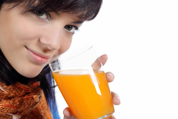 istock Beautiful young woman drinking juice 1161321861