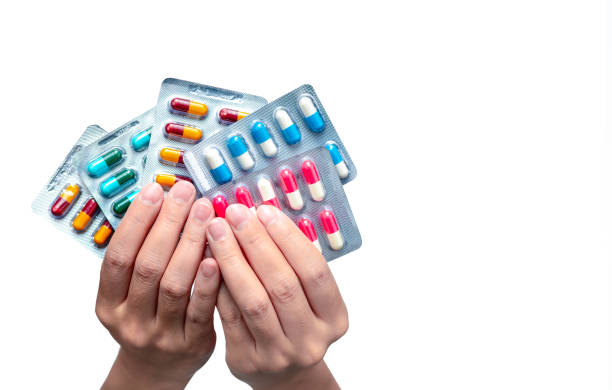 Woman hand holding pack of antibiotic capsule pills isolated on white background. Giving or receiving drug. Antibiotic drug overuse. Antimicrobial drug resistance. Pharmaceutical product. Healthcare. mujer mano sosteniendo paquete de píldoras de cápsulas antibióticas aisladas sobre fondo blanco. dar o recibir drogas. uso excesivo de antibióticos. resistencia a los medicamentos antimicrobianos. producto farmacéutico. atención sanitaria.