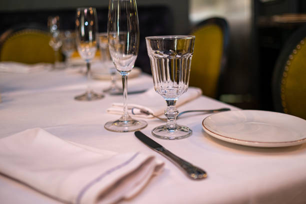 istock Natural light or daylight shot of modern restaurant table set for a lunch. Shallow focus on wine glass. Empty glasses set in restaurant. 1161326834