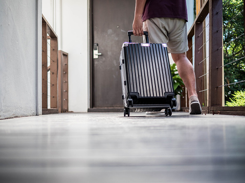 Men wear shorts that are dragging their luggage to accommodation to travel on holiday.