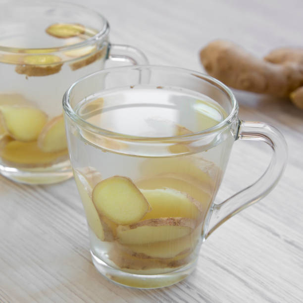 istock Homemade ginger tea with lemon on a white wooden background, side view. Close-up. 1161328876