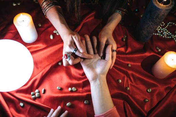 Fortune teller reading from palm Young female fortune teller reading from palm. woman fortune telling stock pictures, royalty-free photos & images