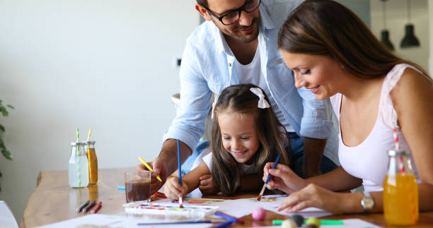 istock Mother and father drawing together with their child 1161329587
