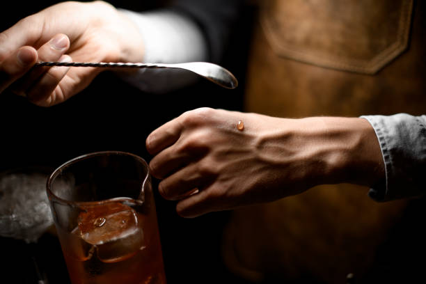 istock Bartender holding a spoon and put a drop on the hand 1161335838