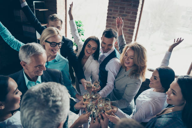 sopra la vista ad alto angolo di bella attraente allegria positiva elegante elegante elegante elegante uomini d'affari professionisti squali celebrando l'azienda grandi progressi sulla postazione di lavoro spaziale - party business toast champagne foto e immagini stock