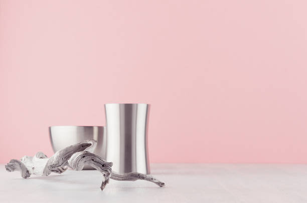 istock Simplicity elegant home decor with silver elegant glossy bowl, vase, dried banch on white wood board and soft light pink background. 1161337018