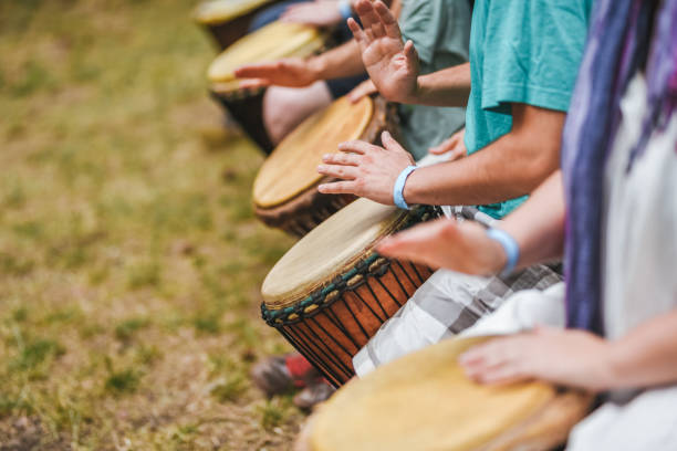 People playing hand drums during an outdoor workshop stock photo