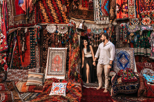 Man and woman in the store. Couple in love in Turkey. Man and woman in the Eastern country. Happy couple travels the world. Persian shop. Tourists in store. Oriental carpet. Istanbul. Follow me stock photo