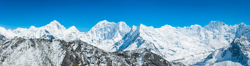Sweeping panoramic vista across the high altitude peaks of the Khumbu, from the summit pyramids of Makalu (8481m), Baruntse (7219m) overlooking the fluted hanging glaciers of Island Peak (6189m) to the summit of Chamlang (7319m) deep in the mountain wilderness of the Himalayas, Nepal.