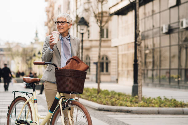 istock Woman pushing bike and drinking coffee 1161341094