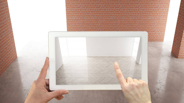 istock Augmented reality concept. Hand holding tablet with AR application used to simulate furniture and design products in interior construction site, empty interior, parquet floor, top view 1161341397