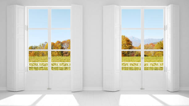 istock Stylish empty room with panoramic windows close-up, classic shutters, classic balcony. Green park, meadow with trees. White background with copy space, interior design concept 1161342226
