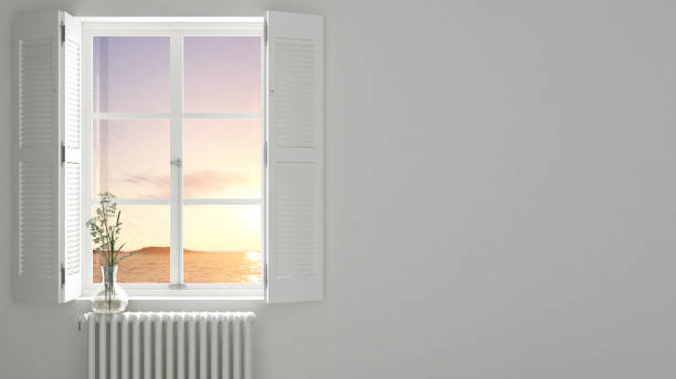 istock Stylish empty room with panoramic window close-up, classic shutters, glass vase with flowers. Sea landscape, sunset. White background with copy space, interior design concept 1161344308